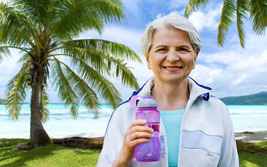 Image showing sporty senior woman with bottle of water at park