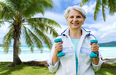 Image showing senior woman with dumbbells exercising at park