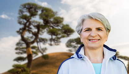 Image showing smiling sporty senior woman at summer park