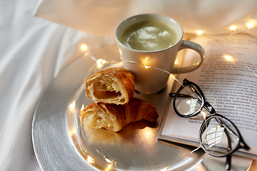 Image showing croissants, matcha tea, book and glasses in bed