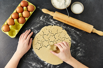 Image showing hands cutting dough with star mold on table