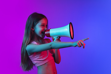 Image showing Little caucasian girl\'s portrait isolated on gradient pink-blue background in neon light.