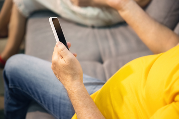 Image showing Couple of seniors spending time together being quarantined - caucasians mature and retired man and woman using modern gadgets, talking, drinking tea