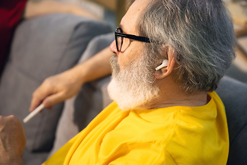 Image showing Mature man spending time being quarantined - caucasian man using modern gadgets, drinking tea