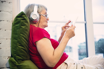 Image showing Mature woman spending time being quarantined - caucasian woman using modern gadgets, drinking tea