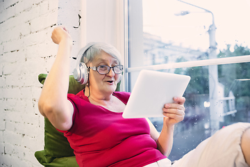 Image showing Mature woman spending time being quarantined - caucasian woman using modern gadgets, drinking tea