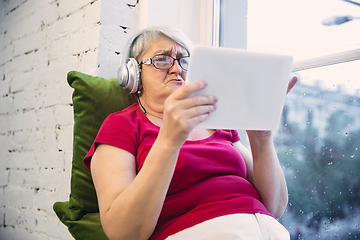 Image showing Mature woman spending time being quarantined - caucasian woman using modern gadgets, drinking tea