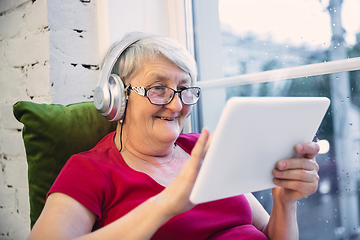 Image showing Mature woman spending time being quarantined - caucasian woman using modern gadgets, drinking tea