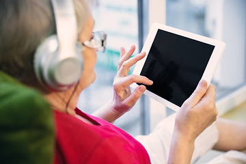 Image showing Mature woman spending time being quarantined - caucasian woman using modern gadgets, drinking tea