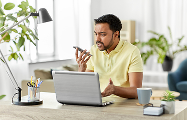 Image showing man recording voice on smartphone at home office