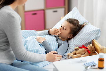 Image showing mother and sick little daughter in bed at home