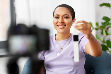 Image showing female blogger with camera video blogging at home