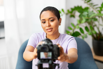 Image showing female video blogger adjusting camera at home