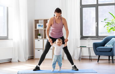 Image showing happy mother with little baby exercising at home