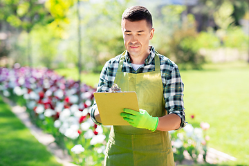 Image showing happy man with clipboard at summer garden