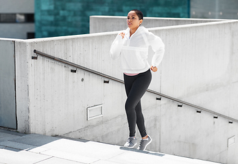 Image showing african american woman running upstairs outdoors