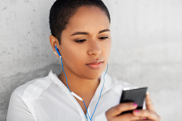 Image showing african american woman with earphones and phone