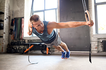 Image showing man doing exercising on gymnastic rings in gym