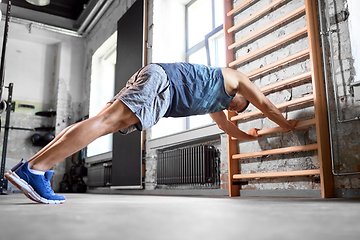 Image showing man exercising on gymnastics wall bars in gym