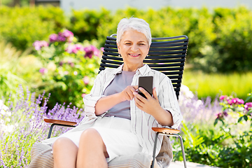 Image showing happy senior woman with phone at summer garden