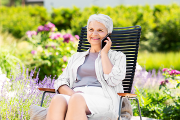 Image showing happy senior woman calling on phone at garden