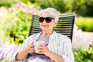 Image showing happy senior woman drinking coffee at garden