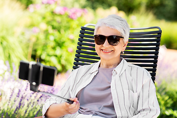 Image showing happy senior woman taking selfie at summer garden