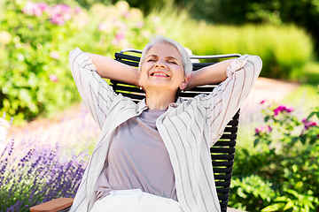 Image showing happy senior woman resting at summer garden