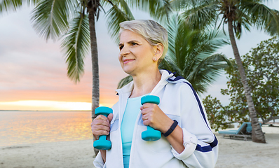 Image showing senior woman with dumbbells exercising at park