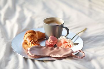 Image showing croissant, coffee and eye sleeping mask in bed