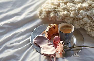 Image showing croissant, coffee and eye sleeping mask in bed