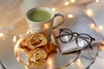 Image showing croissants, matcha tea, book and glasses in bed