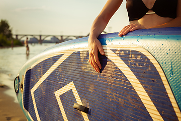 Image showing Young attractive woman carries paddle board, SUP. Active life, sport, leisure activity concept