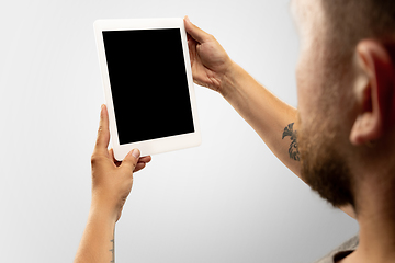 Image showing Close up male hands holding tablet with blank screen during online watching of popular sport matches and championships all around the world. Copyspace for ad