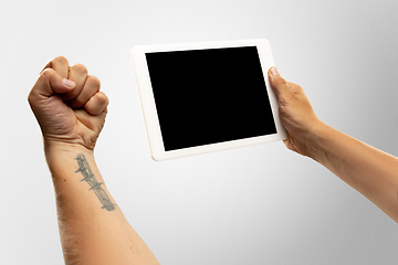 Image showing Close up male hands holding tablet with blank screen during online watching of popular sport matches and championships all around the world. Copyspace for ad