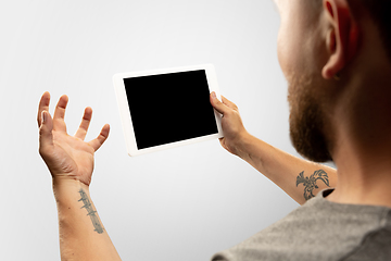 Image showing Close up male hands holding tablet with blank screen during online watching of popular sport matches and championships all around the world. Copyspace for ad