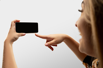 Image showing Close up female hands holding smartphone with blank screen during online watching of popular sport matches and championships all around the world. Copyspace for ad