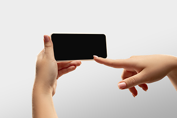 Image showing Close up female hands holding smartphone with blank screen during online watching of popular sport matches and championships all around the world. Copyspace for ad