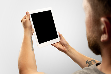 Image showing Close up male hands holding tablet with blank screen during online watching of popular sport matches and championships all around the world. Copyspace for ad