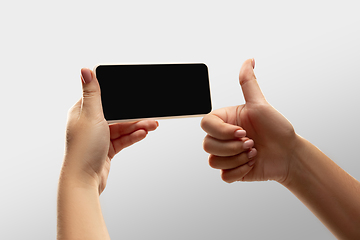 Image showing Close up female hands holding smartphone with blank screen during online watching of popular sport matches and championships all around the world. Copyspace for ad