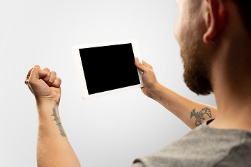 Image showing Close up male hands holding tablet with blank screen during online watching of popular sport matches and championships all around the world. Copyspace for ad