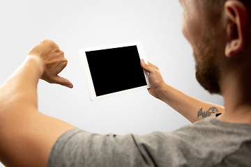 Image showing Close up male hands holding tablet with blank screen during online watching of popular sport matches and championships all around the world. Copyspace for ad