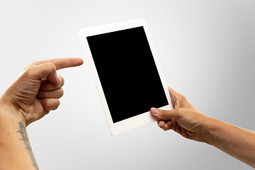 Image showing Close up male hands holding tablet with blank screen during online watching of popular sport matches and championships all around the world. Copyspace for ad