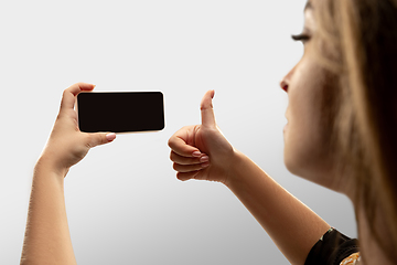 Image showing Close up female hands holding smartphone with blank screen during online watching of popular sport matches and championships all around the world. Copyspace for ad