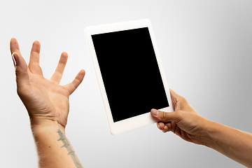 Image showing Close up male hands holding tablet with blank screen during online watching of popular sport matches and championships all around the world. Copyspace for ad