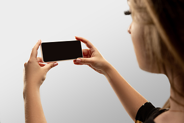 Image showing Close up female hands holding smartphone with blank screen during online watching of popular sport matches and championships all around the world. Copyspace for ad