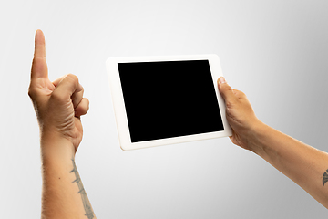 Image showing Close up male hands holding tablet with blank screen during online watching of popular sport matches and championships all around the world. Copyspace for ad