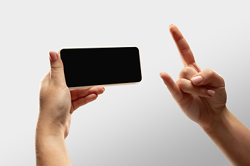 Image showing Close up female hands holding smartphone with blank screen during online watching of popular sport matches and championships all around the world. Copyspace for ad