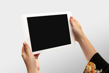 Image showing Close up female hands holding tablet with blank screen during online watching of popular sport matches and championships all around the world. Copyspace for ad