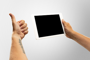 Image showing Close up male hands holding tablet with blank screen during online watching of popular sport matches and championships all around the world. Copyspace for ad